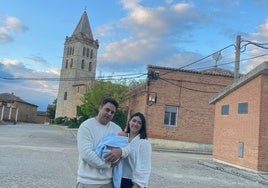 Jorge y Alicia, con su recién nacido, con la torre de la iglesia de Gatón a sus espaldas