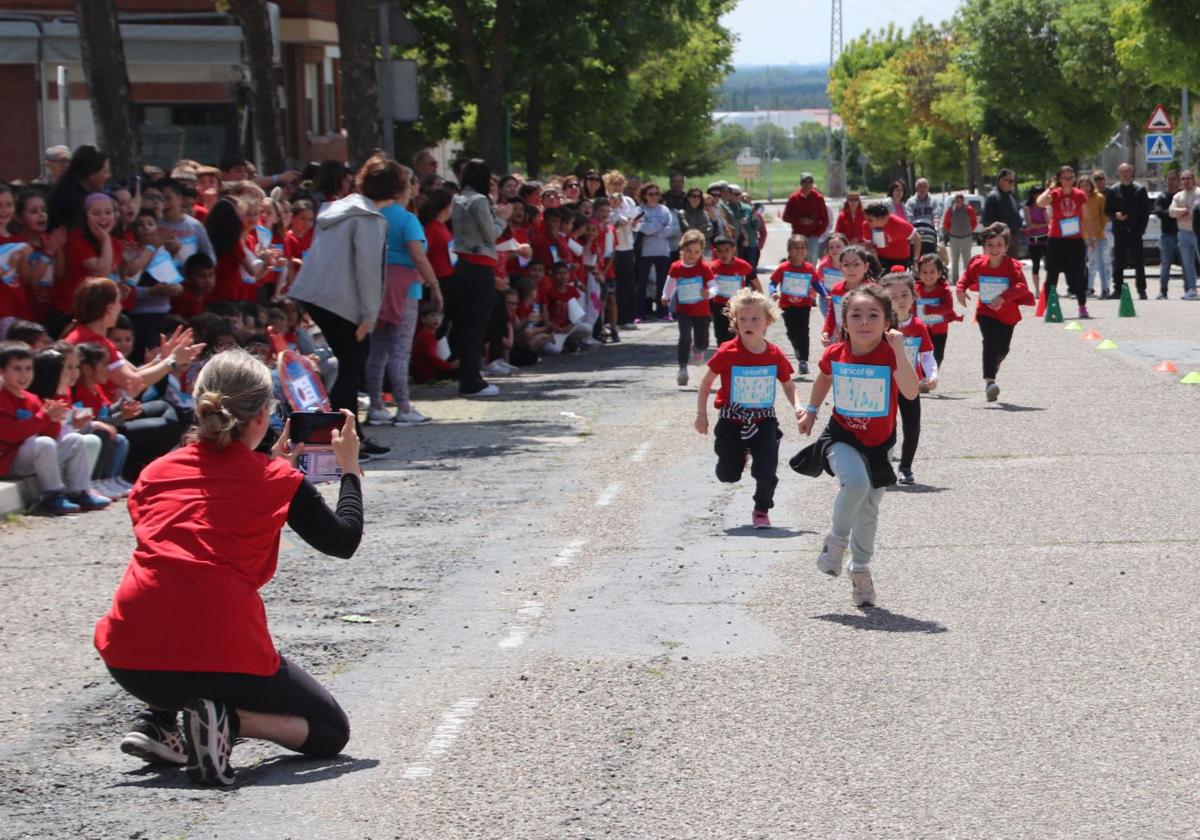 Un grupo de escolares participa en la carrera solidaria de Cuéllar bajo la atenta mirada de familiares, profesores y compañeros.