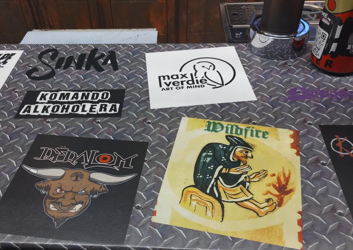 Imagen secundaria 1 - Max Verdié mira la barra de Faroles Rock, donde aparece su nombre entre el de otros artistas, y posa en una de sus mesas.