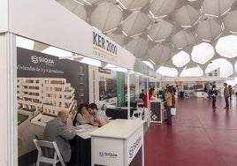 Clientes potenciales informándose en el expositor de Ker 2000