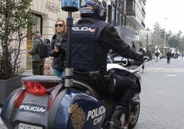 Un policía nacional patrullando en moto por el centro de la ciudad.