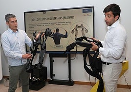 Borja Álvarez, a la izquierda, y Santiago Lajo sostienen unos exoesqueletos, ayer en la jornada de la Cámara de Comercio.