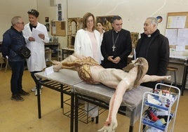 El obispo de Palencia, entre la presidenta de la Diputación y el delegado diocesano de patrimonio, observa la figura del Cristo crucificado de Paredes de Nava.