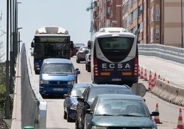Dos autobuses, uno interurbano y otro urbano, se cruzan este miércoles a mediodía sobre el viaducto.