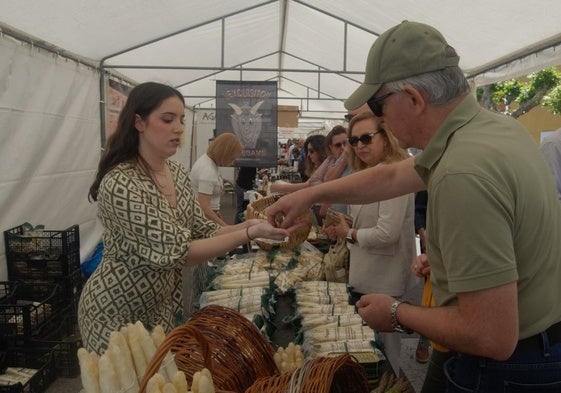 Una persona compra en uno de los puestos de la feria.