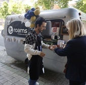 Varias personas se detienen a conocer los servicios de Roams y a tomar un café.