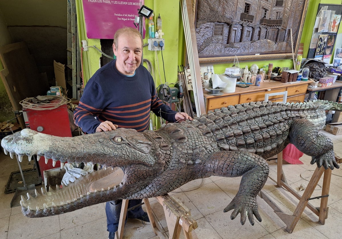 Ángel Martín posa junto al cocodrilo en el interior de su taller