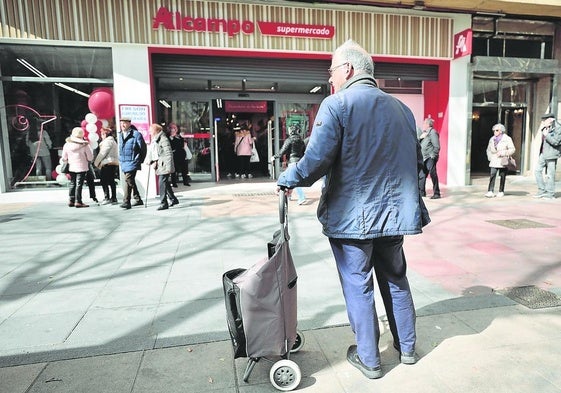 Un cliente espera con su carro de la compra delante del supermercado del paseo de Zorrilla 84 de Valladolid, con motivo de su inauguración como Alcampo en marzo de 2023.