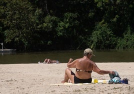 Una mujer toma el sol en la playa de Las Moreras de Valladolid, el año pasado.