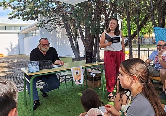 Isabel Sigüenza durante la presentación del libro rodeada de la comunidad educativa. Junto a ella, el poeta Franciso Soto