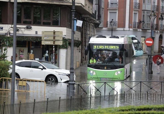 Una autobús y un coche, atrapados por una balsa de agua este martes en Valladolid.