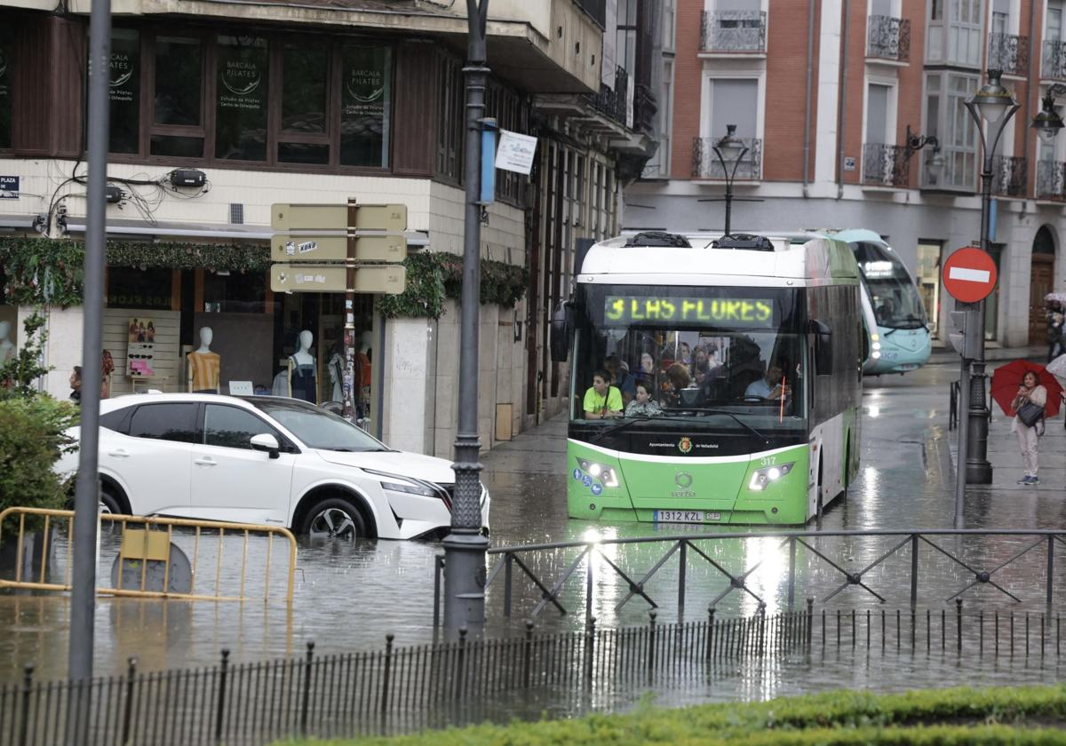 Una autobús y un coche, atrapados por una balsa de agua este martes en Valladolid.