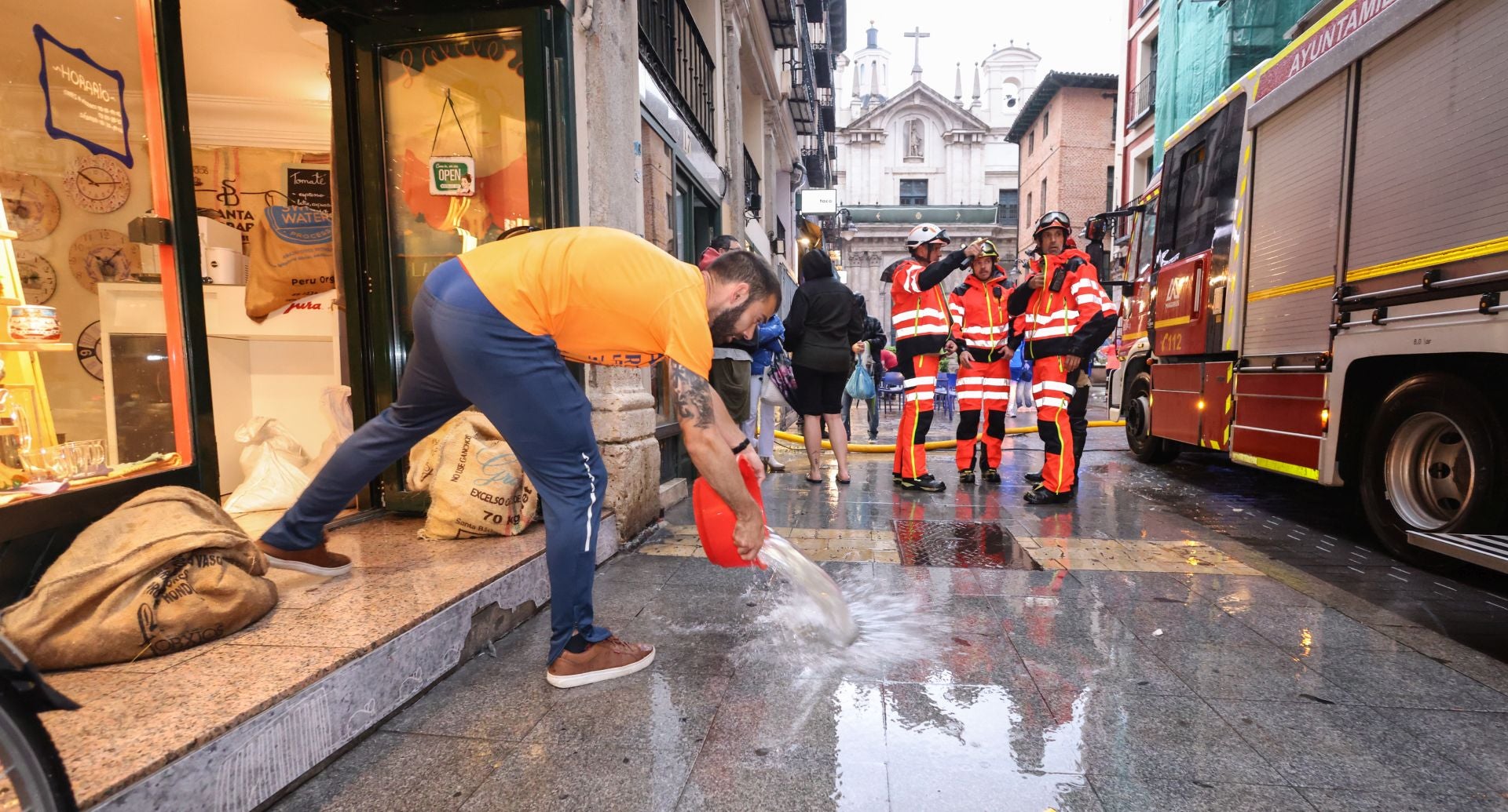 Comerciantes y bomberos trabajan para achicar agua en la calle Platerías.