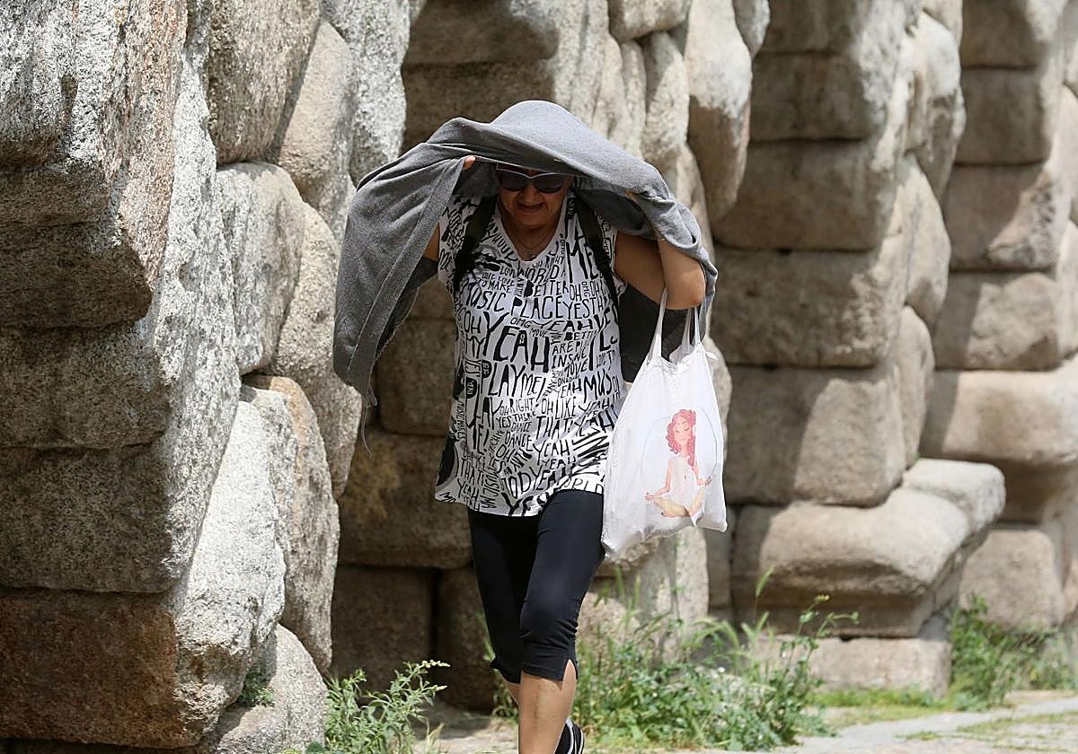 Una mujer se protege del sol en una jornada calurosa en Segovia.