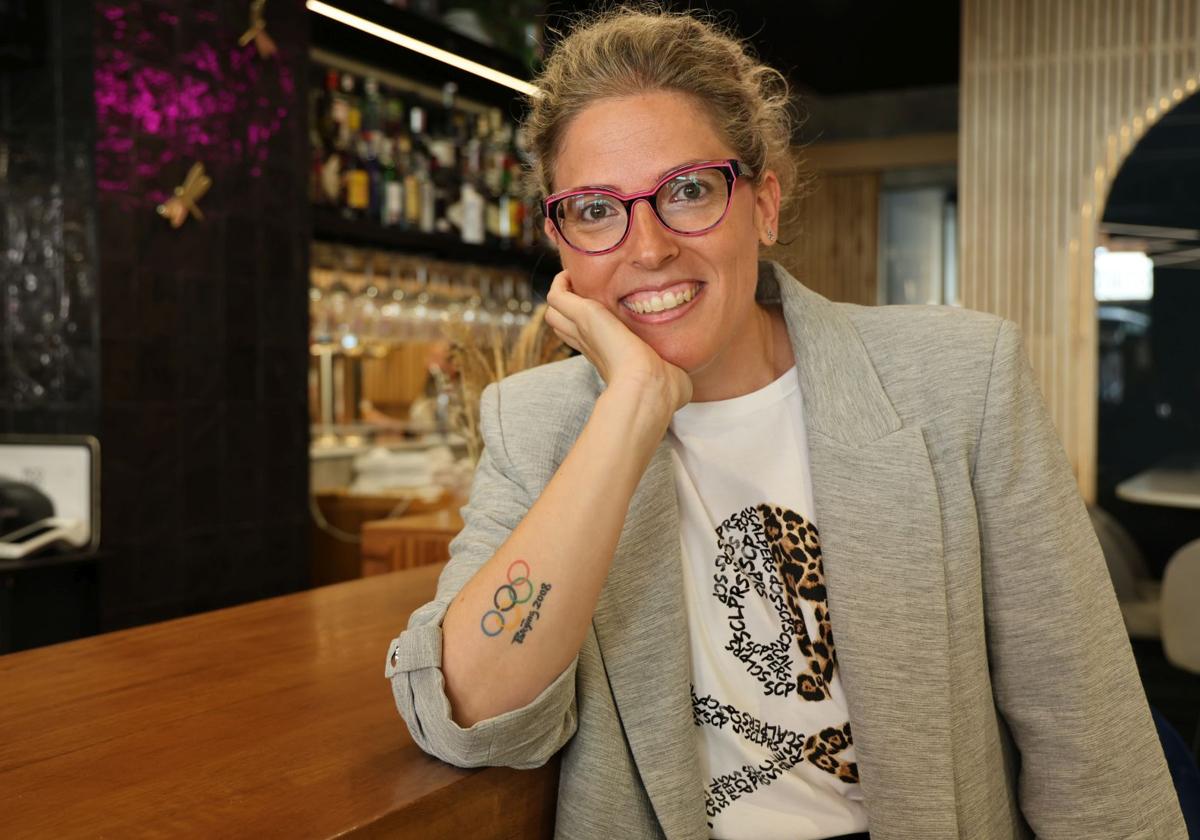 La olímpica vallisoletana Laura López posa en la barra del restaurante Pico Fino y luce su tatuaje que conmemora la medalla de plata que ganó en los Juegos de Pekín de 2008.