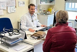 Un médico residente atiende a una paciente en un consultorio.