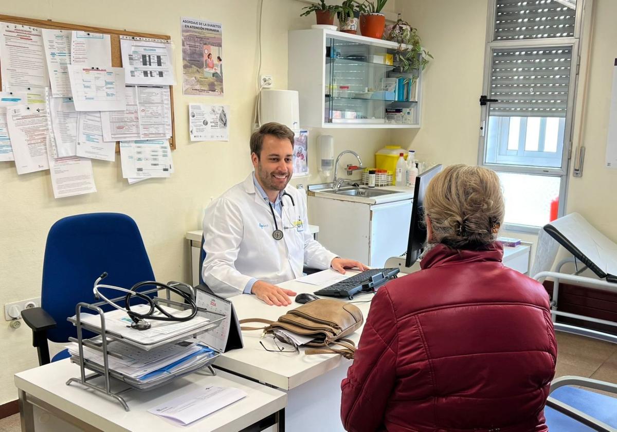 Un médico residente atiende a una paciente en un consultorio.