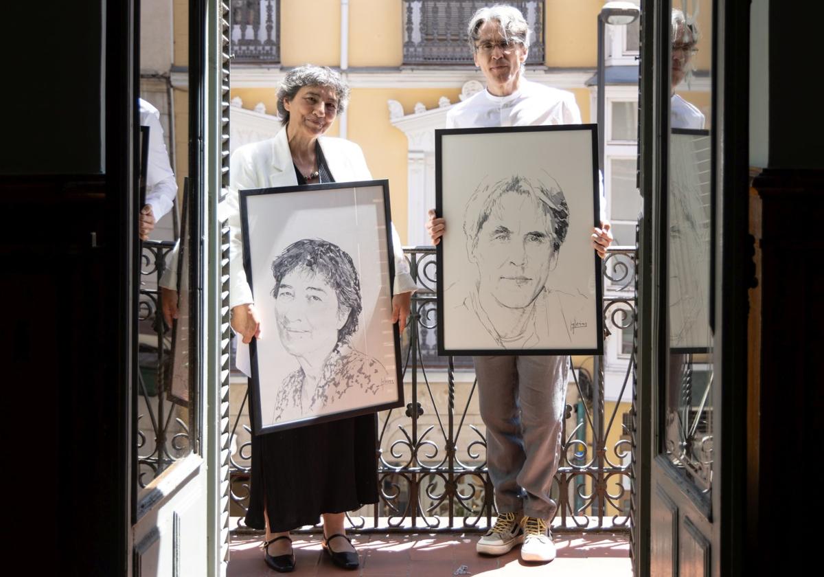 Amalia Iglesias y Rubén Abella con sus retratos, firmados por el pintor salmantino Ángel Iglesias.
