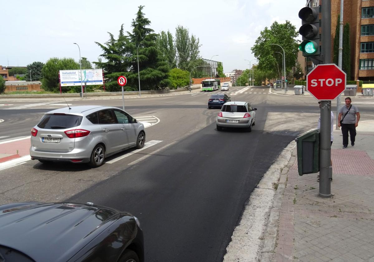 Imagen principal - El cruce de Hernando de Acuña con Adolfo Miaja de la Muela, una vez asfaltado y reabierto al tráfico. Debajo, a la izquierda, trabajos de asfaltado en el tramo inicial de Adolfo Miaja de la Muela y los operarios regulando la circulación.