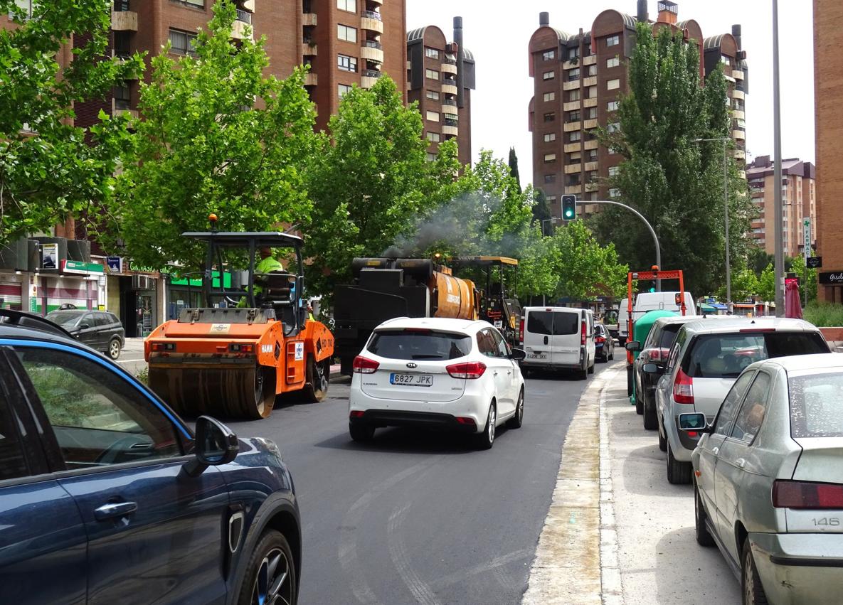 Imagen secundaria 1 - El cruce de Hernando de Acuña con Adolfo Miaja de la Muela, una vez asfaltado y reabierto al tráfico. Debajo, a la izquierda, trabajos de asfaltado en el tramo inicial de Adolfo Miaja de la Muela y los operarios regulando la circulación.