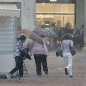 Tres mujeres corren para protegerse de la fuerte tormenta del 3 de junio en Valladolid.