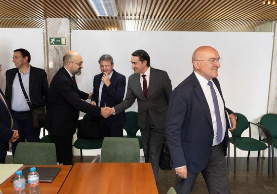 Jesús Julio Carnero se dirige a su sitio a la llegada a la reunión mientras Juan Carlos Suárez-Quiñones (Junta) saluda al presidente de Adif, Luis Pedro Marco, en presencia de José Antonio Santano.