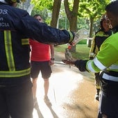 Los bomberos refrescan con agua a una de las aves tras el incendio, que afectó a las jaulas y causó la muerte de varios animales.