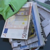 Recortes de periódico tapados por billetes como los utilizados para el timo del tocomocho.
