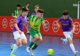 Un jugador del Sporting Nava trata de marcharse entre dos rivales.