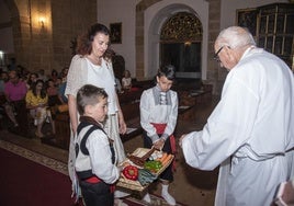 Dos niños vestidos con indumentaria tradicional, durante la ofrenda de frutos.