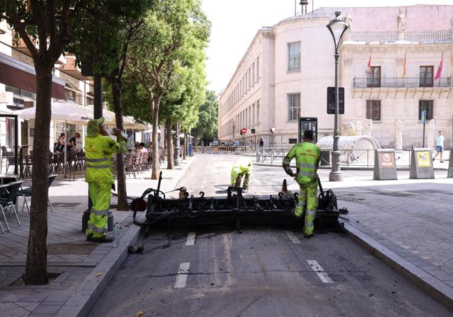 Los operarios esperan al inicio de la calle Duque de Lerma con la intervención parada por una avería de la máquina.