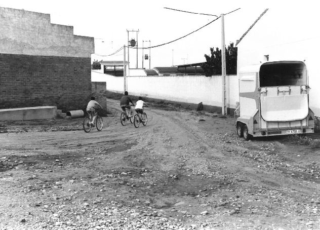 Tres niños circulan en bicicleta por una de las calles de la localidad en junio de 1994.