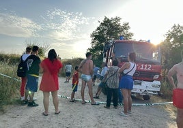 Bañistas en la zona donde se busca al joven desaparecido en Alba de Tormes junto a un campeón de bomberos de la Diputación de Salamanca.