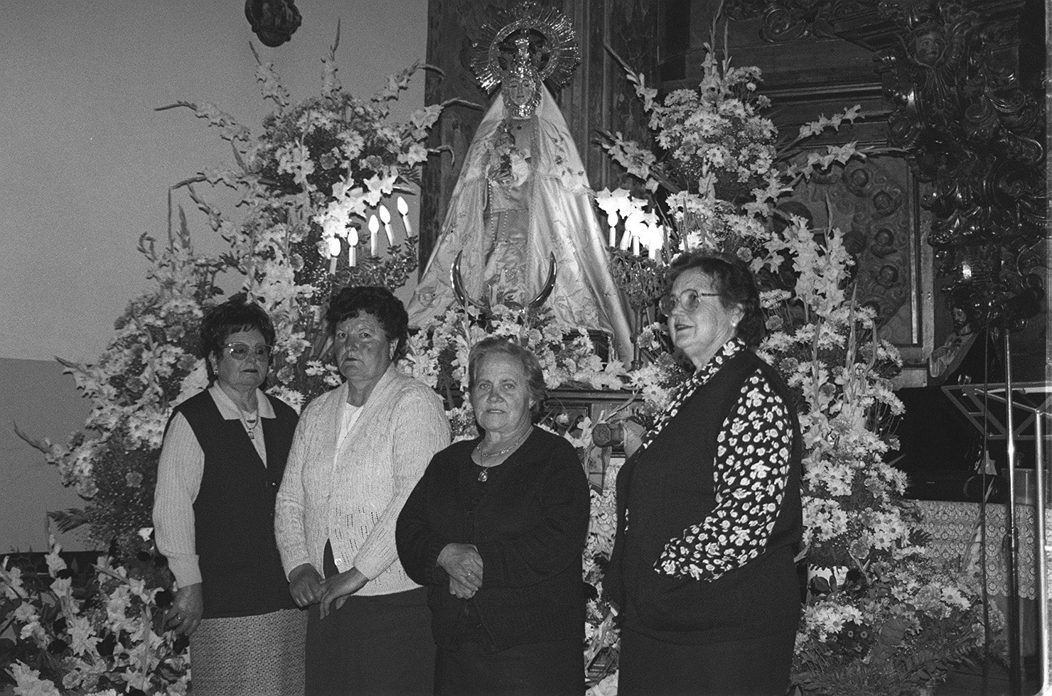 Las cuatro mujeres que cuidan la iglesia de Valdestillas, junto a la Virgen de los Milagros, en mayo de 1999.