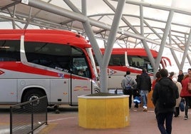 Varias personas esperan su turno para subir a un autobús.