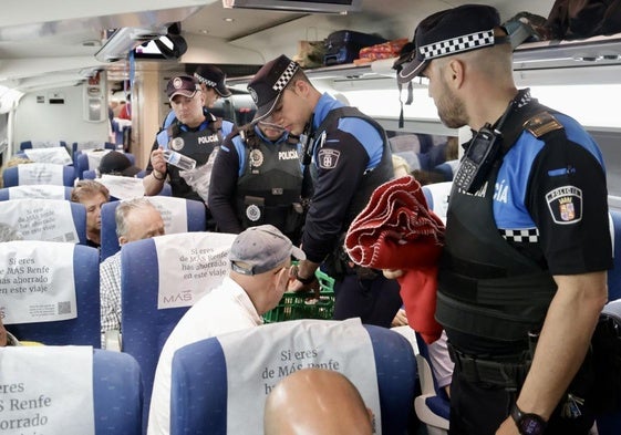 Agentes de la Policía Local de Valladolid distribuyen agua, alimentos y mantas entre los pasajeros de un tren parado en la estación Campo Grande como consecuencia del apagón.