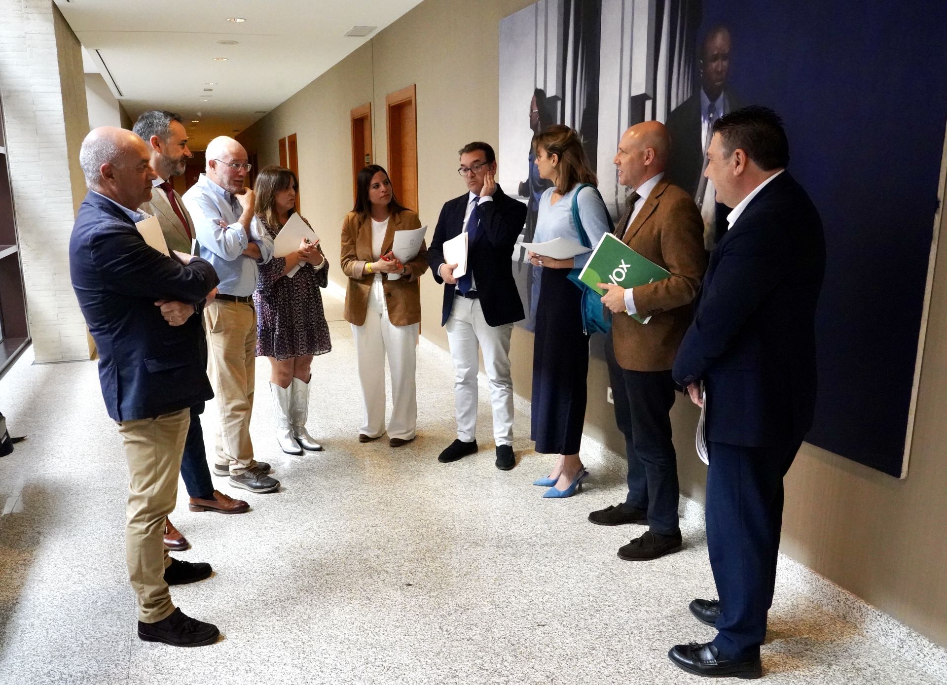 Miembros de la Cortes esperan, junto con la directora general de la Junta, para entrar en la Junta de Portavoces.