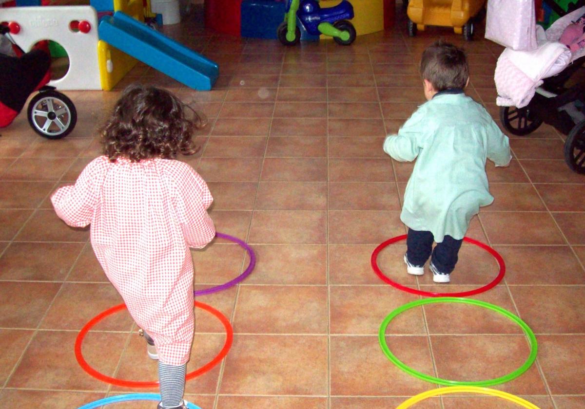 Dos pequeños juegan en un aula.