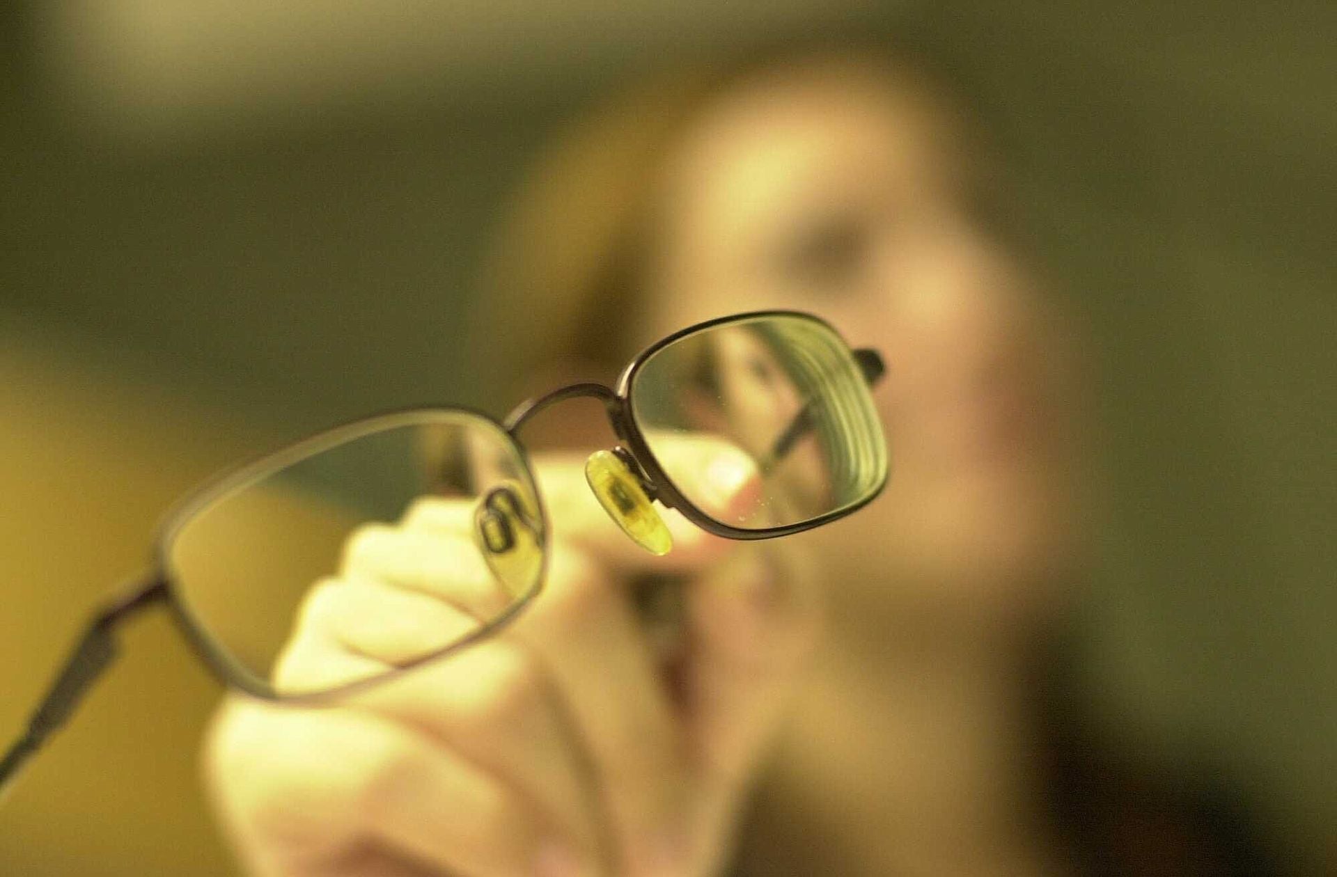 Una mujer muestra las gafas que utiliza.