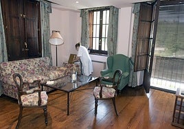 Una mujer coloca el mobiliario de una estancia en un apartamento turístico de Segovia.