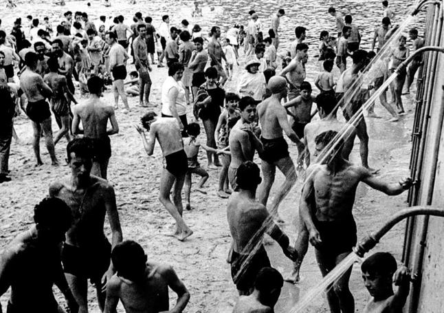 Bañistas se duchan en la playa de Las Moreras en los años sesenta.