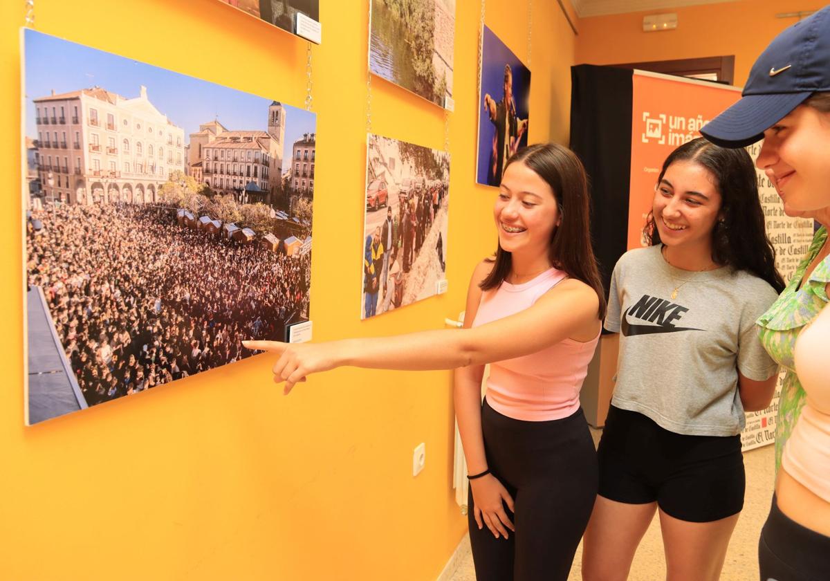 Tres chicas comentan una de las fotografías de la exposición.