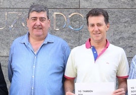 Roberto Hernández, sin carteles, acompañado por compañeros con letreros de apoyo.