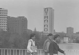 Unos jóvenes pasean por el puente del Poniente con el edificio de Duque de Lerma, al fondo, adornado con la famosa pintada.