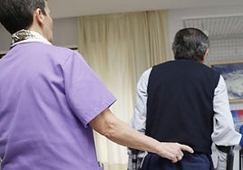 Imagen de archivo de una trabajadora de una residencia de Palencia ayudando a una persona mayor.