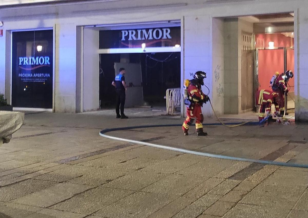 Imagen secundaria 1 - Los bomberos apagan el incendio en el local de la Calle Mayor.