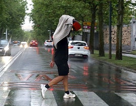 Un hombre cruza un paso de peatones durante una tormenta.
