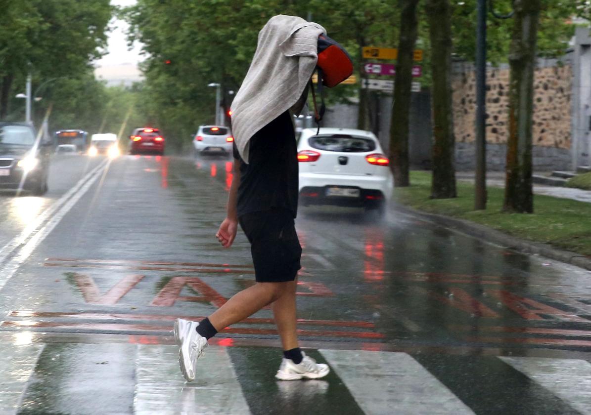 Un hombre cruza un paso de peatones durante una tormenta.