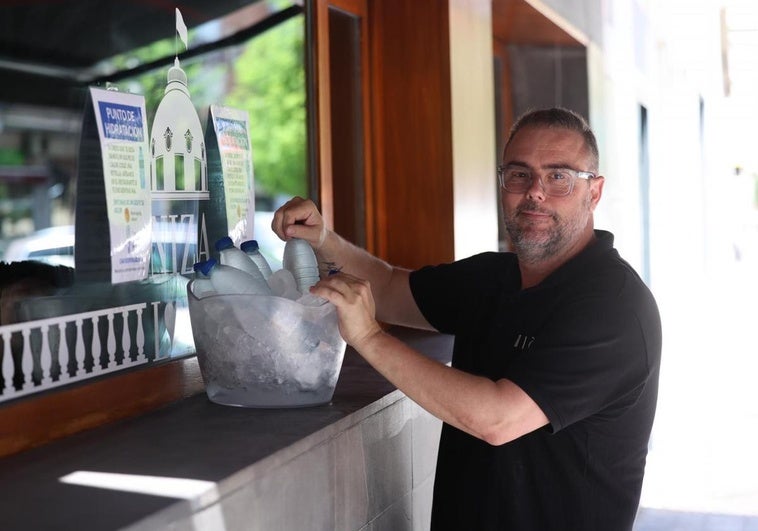 Gonzalo Soriano, del restaurante Niza, prepara su punto de hidratación en la esquina de las calles Padilla y Empecinado.