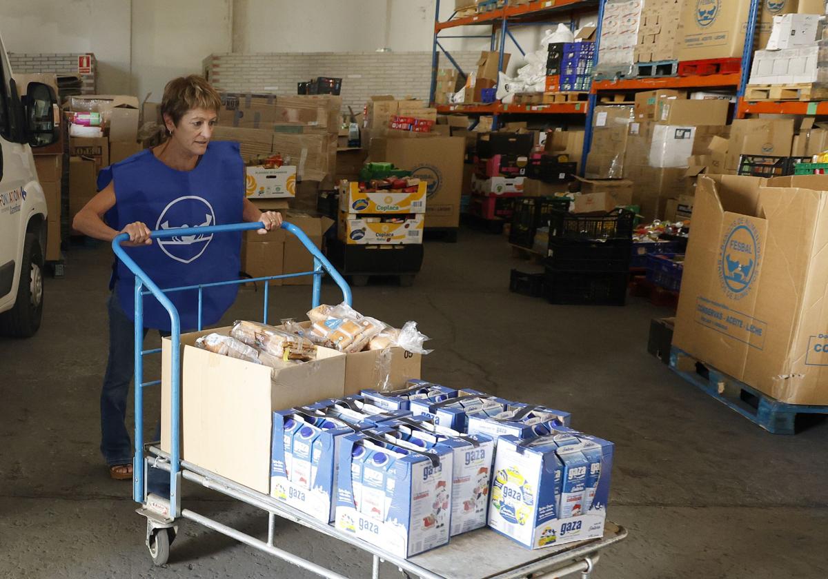 La secretaria del Banco de Alimentos, Rosa Ortega, coloca productos en la sede de la entidad.